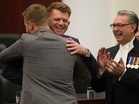 Wildrose leader Brian Michael Jean (MLA for Fort McMurray-Conklin) hugs Strathmore-Brooks MLA Derek Gerhard Fildebrandt and members of the Wildrose caucus are sworn-in at the Alberta Legislature, in Edmonton Alta. on Monday June 1, 2015. Speaker of the Alberta Legislative Assembly Gene Zwozdesky is pictured right. David Bloom/Postmedia Network