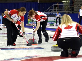 Team Canada third Kaitlyn Lawes, left, and Dawn McEwen, middle,  sweep for Jennifer Jones during the morning draw on Friday February 26, 2016 at the Scotties Tournament of Hearts at Revolution Place in Grande Prairie, Alta. (Postmedia Network)
