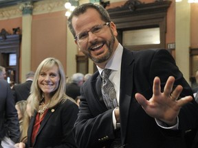In this Jan. 14, 2015 file photo, Rep. Cindy Gamrat,  and Rep Todd Courser, wave to reporters in the House of Representatives in Lansing, Mich. An investigation of the Michigan lawmakers who had an extramarital affair alleges numerous instances of deceptive and “outright dishonest” conduct to cover it up. (Dale G. Young /Detroit News via AP)