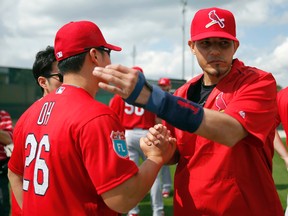 St. Louis Cardinals catcher Yadier Molina, right, gives a pat on the back to pitcher Seung Hwan Oh, of South Korea, during spring training baseball practice Thursday, Feb. 18, 2016, in Jupiter, Fla. (AP Photo/Jeff Roberson)