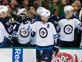 Blake Wheeler (26) is congratulated by the bench after scoring against the Dallas Stars in the first period on Thursday night. (AP Photo/Tony Gutierrez)