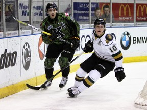 Kingston Frontenacs Roland McKeown and London Knights winger Christian Dvorak chase the puck from the from the Fronts net during the first period of Ontario Hockey League action at the Rogers KRock Centre in Kingston, Ont. on Friday February 26, 2016. Steph Crosier/Kingston Whig-Standard/Postmedia Network