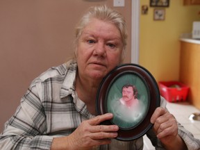 Patricia Newman poses with a photo of her brother, Gary, in her Barrie home. (Tracy McLaughlin/Toronto Sun/Postmedia Network)