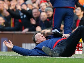 Manchester United manager Louis van Gaal lies on the side of the pitch to demonstrate a foul to the fourth official. (REUTERS)