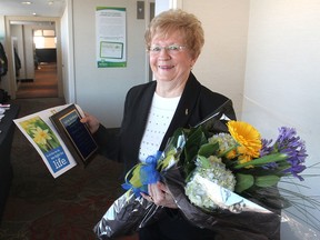Sylvia Harkness holds the plaque and bouquet she received during a ceremony in Kingston, Ont. on Friday, Feb. 26, 2016 for being a volunteer for the local office of the Canadian Cancer Society for 55 years. Michael Lea The Whig-Standard Postmedia Network