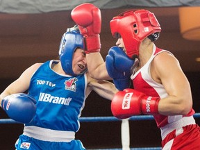 Caroline Veyre, right, of the Northwest Territories, trades punches with Sabrina Aubin-Boucher, of Quebec, on her way to winning a unanimous decision in their 60kg bout at the Canadian Olympic Boxing trials, in Montreal, on Thursday, Dec. 10, 2015.THE CANADIAN PRESS/Ryan Remiorz