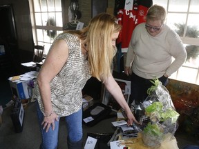 Cathy Reid (left) and Bunny Empey sort through items in a live auction to raise funds for Owen Thompson and his family Sunday in Stirling.