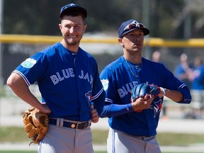 Shortstop Troy Tulowitzki (left) and second baseman Ryan Goins await their turn for fielding practice during the Blue Jays spring camp yesterday in Dunedin, Fla.  The two infielders were responsible for a much-improved defence up the middle during the latter stages of last season. (Frank Gunn, The Canadian Press)