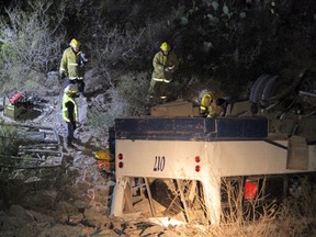 Rescue workers inspect a bus following an accident in Mapimi, in Durango state, Mexico, February 27, 2016. Twelve people were killed after a tourist bus carrying 40 passengers plunged 45 meters off of a cliff in the northern state of Durango, authorities said early on Sunday.The accident occurred on Saturday in the municipality of Mapimi, according to the Twitter account of the local emergency services. Picture taken February 27, 2016. REUTERS/Stringer