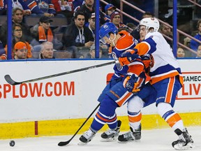 Edmonton Oilers forward Lauri Korpikoski and New York Islanders defencemen Ryan Pulock chase a loose puck Sunday at Rexall Place. (Perry Nelson-USA TODAY Sports)