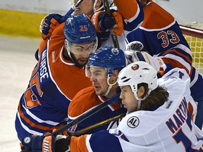 Battles in front of Edmonton Oilers net Adam Clendening (27) and Darnell Nurse (25) and New York Islanders Matt Martin (17) and Anders Lee (27) during NHL action at Rexall Place Sunday. (Ed Kaiser)