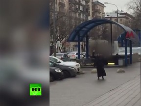 Video footage shows a woman in Moscow, waving a child's severed head in the air, shouting that she is a terrorist. (Video screenshot)