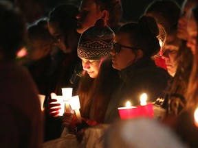 In this Feb. 23, 2016 photo, people attend a vigil on the soccer field of Mattawan High School in Mattawan, Mich., to honor Tyler and Richard Smith, two of the victims of a shooting. Jason Dalton admitted to gunning down randomly chosen victims in and around Kalamazoo, Mich., Saturday, Feb. 20 — attacks apparently carried out over hours during which he also ferried passengers around town as an Uber driver. (Chelsea Purgahn/Kalamazoo Gazette-MLive Media Group via AP)