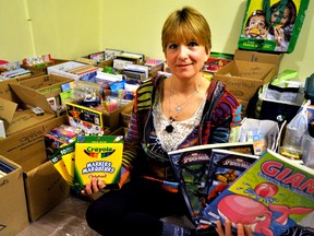 Kathy Bulmer sits next to boxes of arts supplies stored in her basement in London Ont. February 24, 2016. In honour of her late daughter Courtney, Bulmer is collecting art supplies for the Children’s Health Foundation until April 18. CHRIS MONTANINI\LONDONER\POSTMEDIA NETWORK