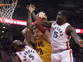 Cleveland Cavaliers' Timofey Mozgov, centre, is fouled by Toronto Raptors' DeMarre Carroll, left, as Raptors Anthony Bennett defends during first half NBA pre-season basketball action in Toronto on Sunday, October 18, 2015. (THE CANADIAN PRESS/Chris Young)