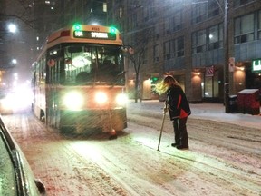 A TTC streetcar is stopped in its track while the engineer attempts to clears snow on its path during a blizzard in Toronto February 1, 2015. (REUTERS/Hyungwon Kang)