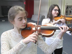 Isobel Moore, left, and Isra Henson, in a practice room below St. Mark's Lutheran Church in Kingston, were two of the participants in the violin category in the annual Kiwanis Music Festival, which continues through Thursday. (Michael Lea/The Whig-Standard)