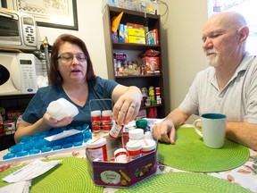 Nancy and James Fortner look through James? medications, which without Nancy?s copay would total roughly $4,000 per month, as they sit in the Kipps Lane apartment the couple shares with James? ex-wife, in London. (CRAIG GLOVER, The London Free Press)