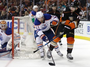 Patrick Maroon, right, shown here battling Oilers forward Anton Lander for the puck during a game last month in Anaheim,was acquired by the Oilers in a trade that sent a fourth-round pick and defenceman prospect Martin Gernat to the Ducks. (AP PHOTO)