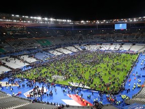 In this Nov.13, 2015 file photo, spectators invade the pitch of the Stade de France stadium after the international friendly soccer France against Germany, in Saint Denis, outside Paris. (AP Photo/Michel Euler, File)