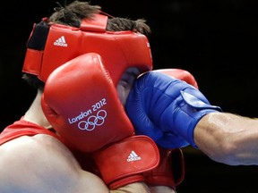 In this Aug. 12, 2012, file photo, Britain’s Freddie Evans is hit by a punch from Kazakhstan’s Serik Sapiyev during a welterweight match at the 2012 Summer Olympics in London. (AP Photo/Patrick Semansky, File)
