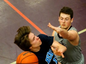 Kingston Blues' Kai Farrell protects his shooting space against Brendan Steele of the Frontenac Falcons during the Eastern Ontario senior boys AA basketball final at Thousands Islands Secondary School in Brockville on Tuesday. (Darcy Cheek/Postmedia Network)