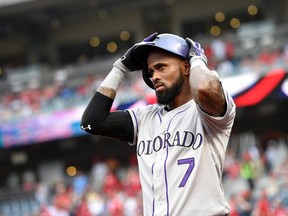 Colorado Rockies shortstop Jose Reye adjusts his batting helmet before a baseball game against the Washington Nationals in Washington on Aug. 7, 2015. Reyes was placed on paid leave Tuesday, Feb. 23, 2016, under Major League Baseball's new domestic violence policy and will not report to spring training. The 32-year-old, a four-time All-Star, was arrested in Hawaii at a Maui resort on Oct. 31 following an argument with his wife and pleaded not guilty to a charge of abuse of a family or household member. THE CANADIAN PRESS/AP, Nick Wass
