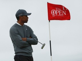 Tiger Woods waits to putt on the 11th green during the first round of the British Open in St. Andrews, Scotland, on July 16, 2015. Woods said he is feeling better but there is no timetable for his return. (Lee Smith/Reuters/Files)