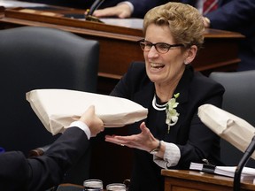 Premier Kathleen Wynne gets handed the 2016 budget February 25, 2016. (Craig Robertson/Toronto Sun)