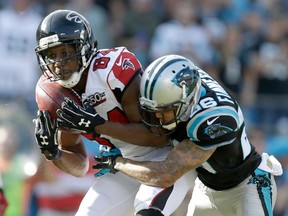 Atlanta Falcons wide receiver Roddy White catches a pass in front of Carolina Panthers defender Cortland Finnegan in Charlotte, N.C., Sunday, Dec. 13, 2015. (AP Photo/Bob Leverone)