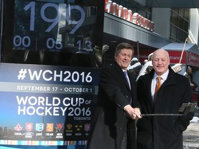 NHL deputy commissioner Bill Daly, right, and Toronto Mayor John Tory take a selfie during the unveiling of the tournament countdown clock for the World Cup of Hockey outside the Air Canada Centre in Toronto on March 2, 2016. (Veronica Henri/Toronto Sun/Postmedia Network)