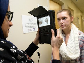 Western University grad student Fatima Bukair uses an iris scanner to capture images of fellow grad student Sommer Froats? eyes. (CRAIG GLOVER, The London Free Press)