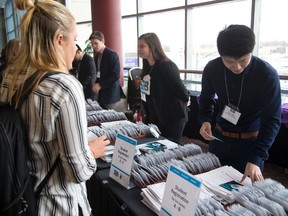 Carly Foster, a Fanshawe College fashion merchandising student, registers with the help of Denny Man of Western University for the Student 2 Business conference at the London Convention Centre Wednesday. (MIKE HENSEN, The London Free Press)