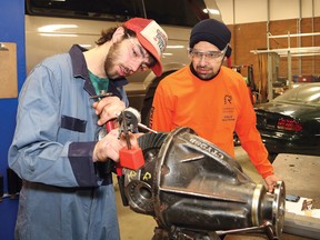 Student judge Sohail Abbas, right, looks on as Confederation Secondary School student Brandon Duggan takes part in an automotive challenge at the Rainbow District School Board's annual Technological Skills Competition at Cambrian College. (John Lappa/Sudbury Star)