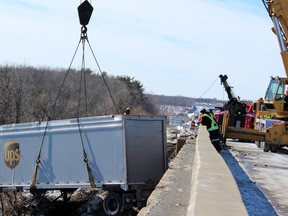 Tow crews remove a UPS transport truck and its two trailers from deep within the ditch off Highway 401 between Montreal Street and Highway 15 in Kingston, Ont. on Thursday March 3, 2016. The truck left the highway the morning of March 2 at approximately 1:30 a.m. No injuries were reported. Steph Crosier/Kingston Whig-Standard/Postmedia Network