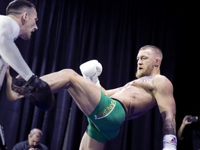 In this photo taken Wednesday, March 2, 2016, UFC featherweight champion Conor McGregor, right, kicks striking coach Owen Roddy during open workouts for UFC 196 at MGM Grand in Las Vegas. (Steve Marcus/Las Vegas Sun via AP)