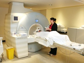 A registered MRI technologist prepares a patient for an MRI scan in this February 7, 2011 file photo at the Owen Sound hospital in Owen Sound, Ont. (JAMES MASTERS/THE SUN TIMES/Postmedia Network)