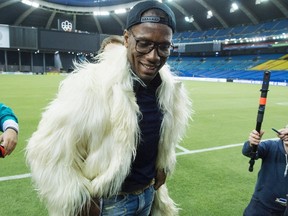 Montreal Impact striker Didier Drogba tries on a coat given to him by an Italian comedian on Thursday. (THE CANADIAN PRESS)