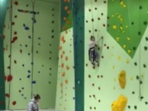 A 55-second video posted on Facebook on Wednesday shows a young woman who appears to be on her phone sitting at the bottom of a climbing wall while a girl struggles to climb it and cries when she can't go on. (Facebook)