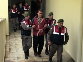 Turkish paramilitary police officers escort Syrian smugglers Muwafaka Alabash, front, and Asem Alfrhad, rear, for their trial in Bodrum, Turkey, on March 4, 2016. A Turkish court on Friday sentenced the two Syrian smugglers to four years and two months each in prison over the death of three-year-old Syrian boy Alan Kurdi and four other people, the state-run Anadolu Agency reported. (AP Photo)