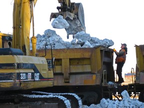 Workers offload an Alaska Railroad train that delivered tons of snow to Anchorage, Alaska, on March 3, 2016, after travelling 360 miles south from Fairbanks. The snow will be used to help provide a picturesque ground cover on the streets for the ceremonial start of the 1,000-mile Iditarod Trail Sled Dog Race in Anchorage, where persistent above-freezing temperatures have melted much of the local snow. (AP Photo/Rachel D'Oro)