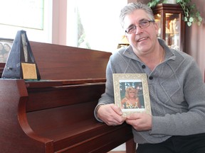 Rick LaBelle, with a photo of his late wife Joanne Klauke-LaBelle, sits at her former piano in his Corunna home Friday. Family and friends are continuing their fundraising efforts for a scholarship in memory of the beloved Harmony for Youth founder. Barbara Simpson/Sarnia Observer/Postmedia Network