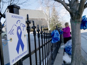 Emily Mountney-Lessard/The Intelligencer
Nancy Roberts helps attach signs and ribbons to a fence at St. Michael's Church in Belleville in advance of Violence Awareness and Random Acts of Kindness Week.