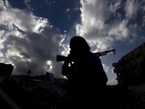 A rebel fighter carries his weapon in the rebel-controlled area of Jobar, a suburb of Damascus, Syria March 3, 2016. REUTERS/Bassam Khabieh