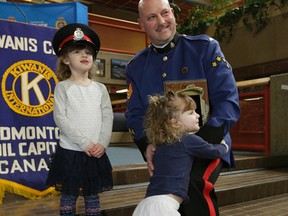 Edmonton Police Service Sgt. Grant Jongejan is congratulated by his daughters Jada (left/4-years-old) and Gemma (right/2-years-old) at police headquarters in Edmonton on March 4, 2016, where he received the 2015 Kiwanis Top Cop Award for his volunteer work with Edmonton high school football teams. (PHOTO BY LARRY WONG/POSTMEDIA)
