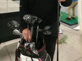 Tour Edge eastern Ontario rep Roy Holdsworth looks over his clubs at the Ottawa-Gatineau Golf Expo. (Tim Baines, Ottawa Sun)