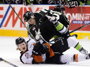 The Edmonton Oil Kings' Colton Kehler (23) and Dysin Mayo (37) collide with the Medicine Hat Tigers' Chad Butcher (21) during second period WHL action at Rexall Place, in Edmonton Alta. on Friday March 4, 2016.