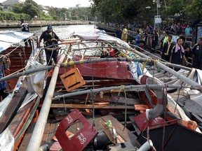 Rescue workers stand next to a river taxi engine which exploded at a canal in Bangkok, Thailand, March 5, 2016.   REUTERS/Dailynews