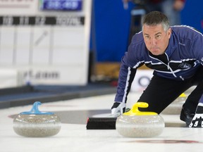 Skip Wayne Middaugh crouches down as he watches a rock slide down the sheet during his match against Team Kean at the Ontario Curling Championships at the Flight Exec Centre in Dorchester, Ont., on Feb. 5, 2015. (CRAIG GLOVER/The London Free Press)