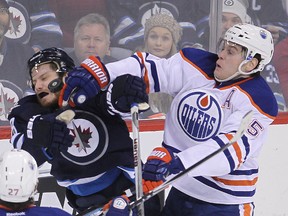Winnipeg Jets center Bryan Little and Edmonton Oilers defenceman Mark Fayne tangle during a recent game in Winnipeg. The two teams will take part in an outdoor NHL game there in late October. (File)